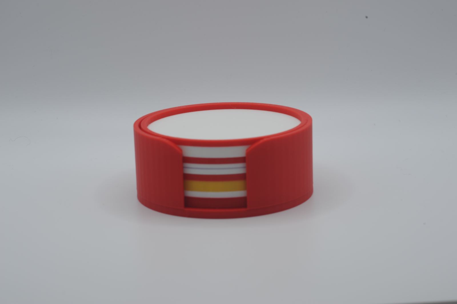 A red coaster holder with colorful coasters stacked inside