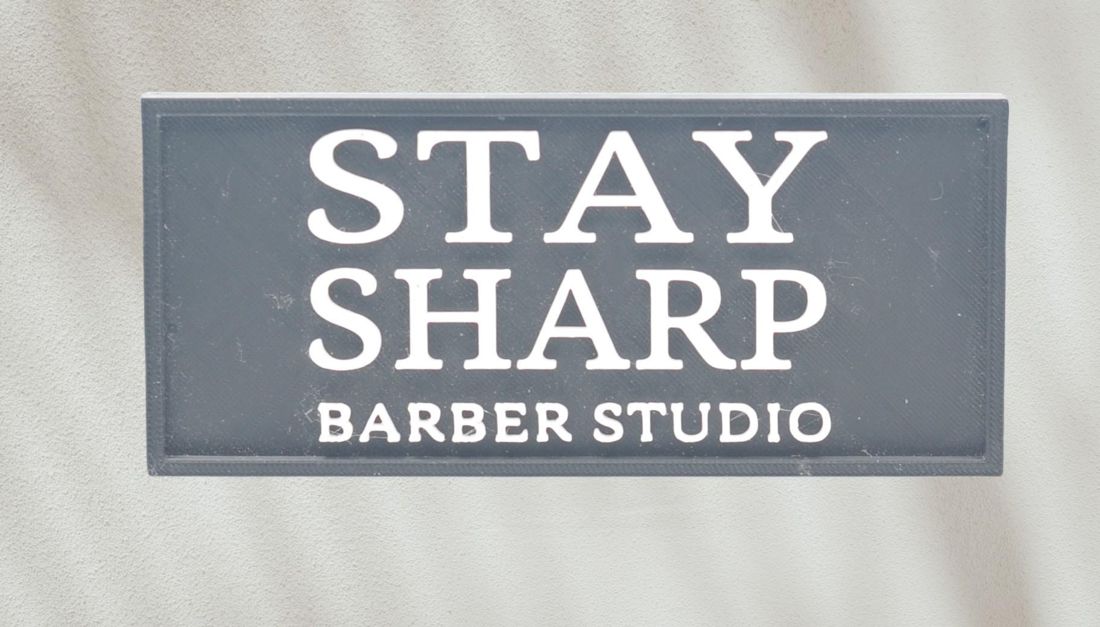 A curved desk sign with a business name